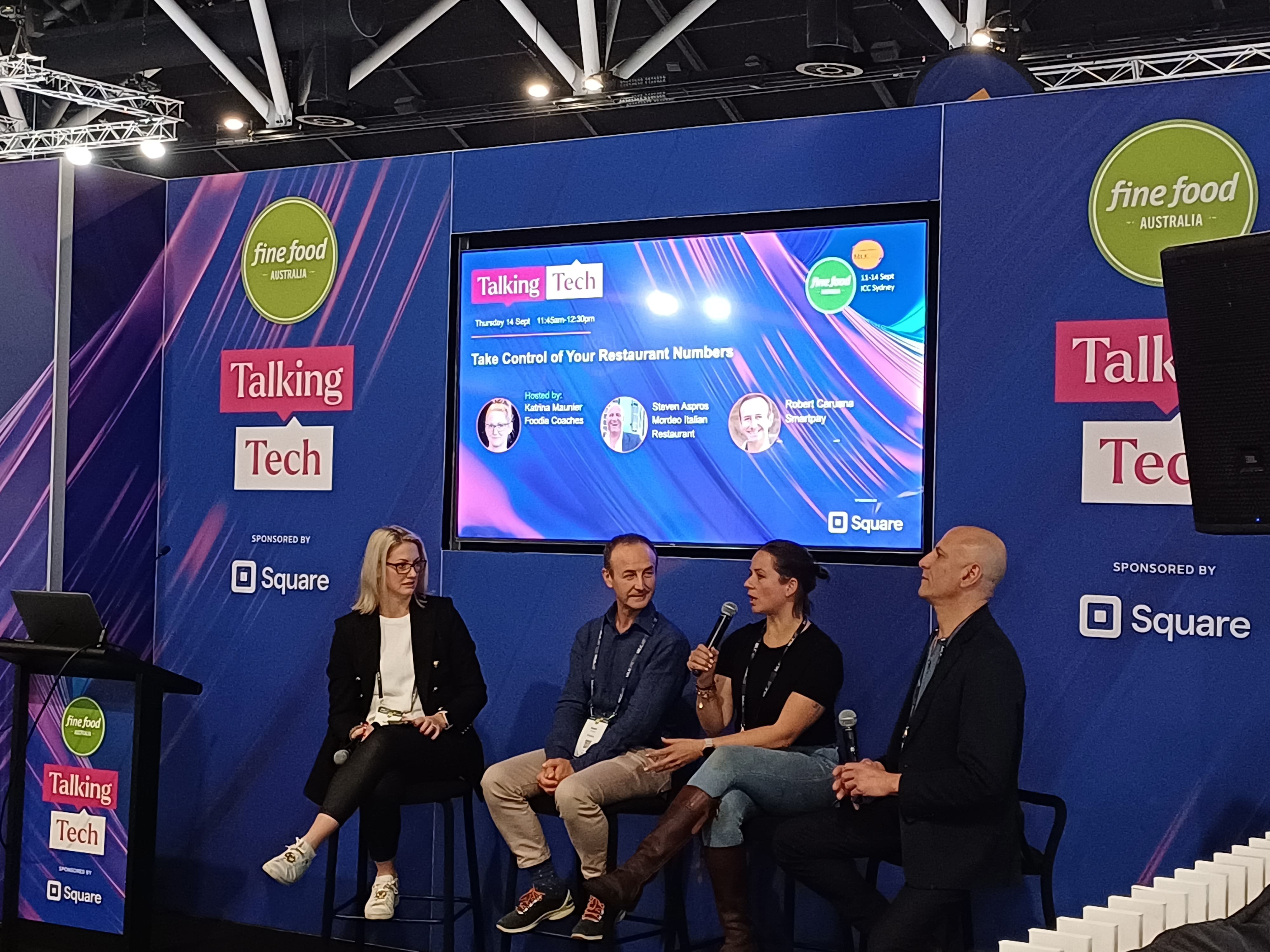 4 people sitting on stage discussing