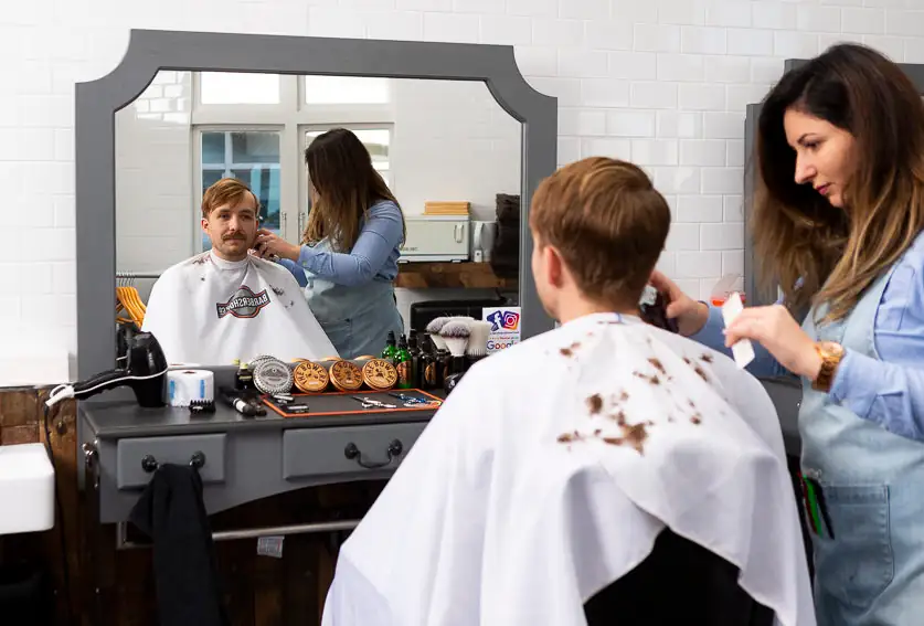Hairdresser cutting client's hair in salon