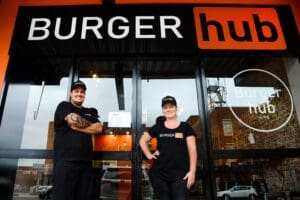 2 people standing infront of Burger Hub Store front
