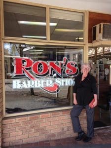 Ron's Barber Shop with lady posing infront
