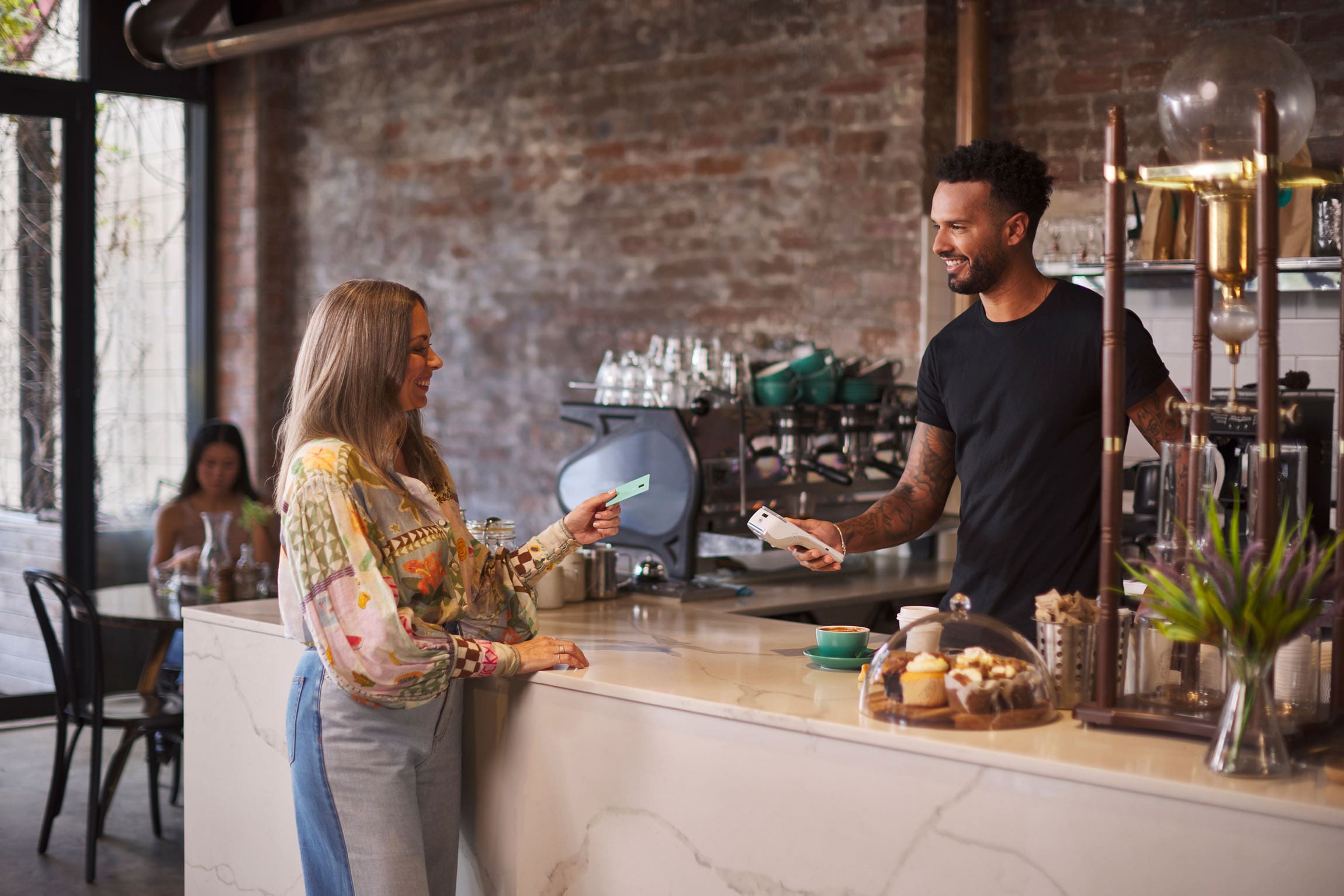 Women going to tap card on Android terminal at Cafe