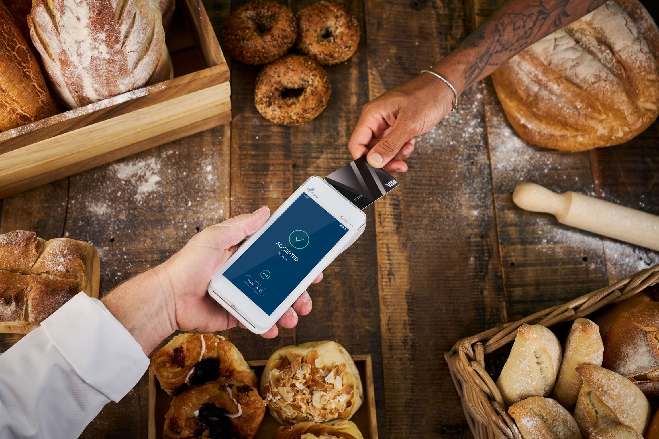 Visa Card accepted payment tapping Android terminal surrounded by pastries