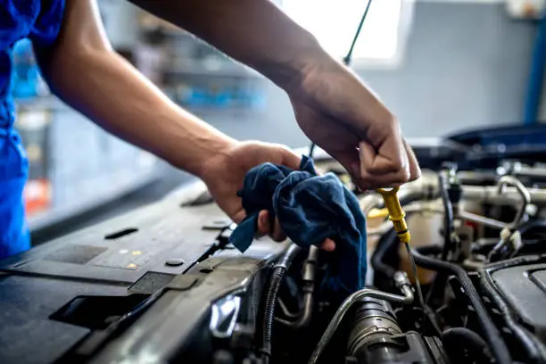 person checking oil in car